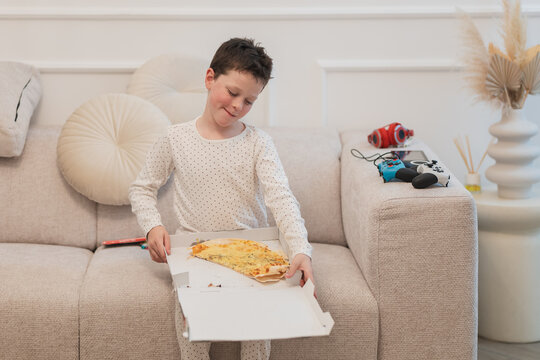 Young boy enjoying pizza slice at home