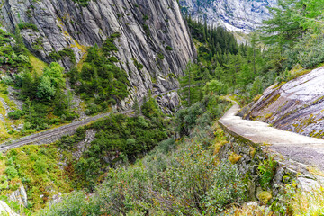 Scenic landscape from hiking trail with aerial view of mountain pass road of Swiss Grimsel pass on a cloudy late summer day. Photo taken September 19th, 2023, Grimsel, Mountain Pass, Switzerland.