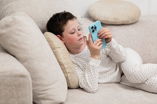 Boy at home focused on smartphone screen