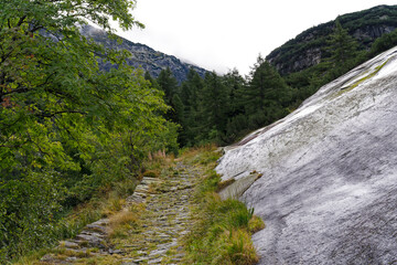 Scenic view of alpine landscape with hiking trail at Swiss mountain pass Grimsel on a cloudy late summer day. Photo taken September 19th, 2023, Grimsel, Canton Bern, Switzerland.