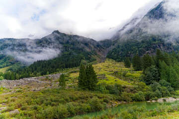 Fototapeta premium Alpine landscape in the Swiss Alps with fog and peak at mountain pass Grimsel on a cloudy late summer day. Photo taken September 19th, 2023, Grimsel, Canton Bern, Switzerland.