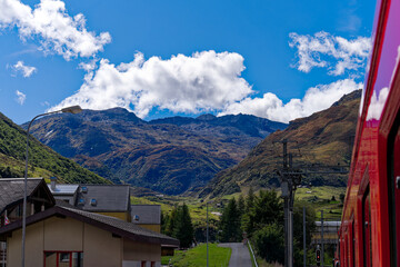 Scenic view of mountain village Realp seen through window of narrow gauge railway train at Urseren...