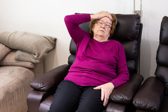 Elderly woman experiencing hypoglycemia symptoms at home