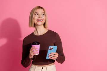 Photo of pretty positive nice girl wear stylish brown clothes hold coffee empty space isolated on pink color background