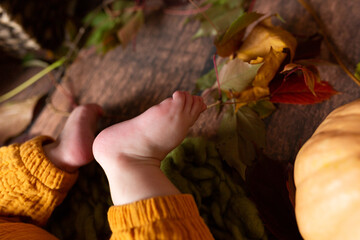 small children's legs in yellow pants on a dark background. small fingers