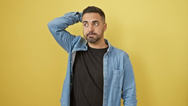 Pensive young hispanic man in denim shirt stands doubtful, wrestling with unsolved question over sunny yellow cutout wall