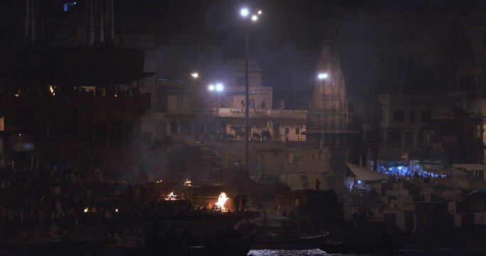 Varanasi, Uttar Pradesh, India. Cremation in process on Manikarnika Ghat. Baba Mashan Nath, Tarkeshwar and Ratneshawar, Tripur Sundari and Ganesh complex. Cinematic Camera movement moving along