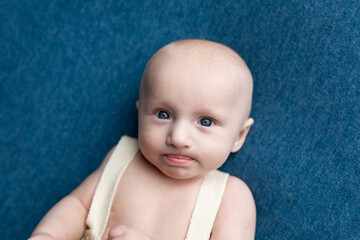 portrait of a small child on a blue background. portrait of a newborn boy. baby's first photo shoot