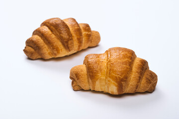 two fresh croissants on white background