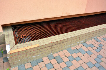 The window basement is covered with a grate in the pavement