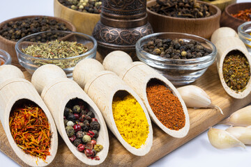 Assortment of oriental spices in glass and wooden dishes.