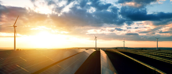 Photovoltaic power station and wind turbines at sunset.Windmill turbines generating green energy electric.Green energy reduce carbon emissions and makes earth cleaner and more ecological. © Miha Creative