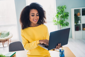 Photo of charming lovely cute woman employee working using netbook office workspace indoors