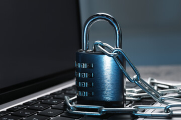 Cyber security. Metal combination padlock with chain on laptop, closeup