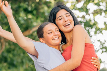 happy friends hugging laughing out loud in summer outdoors