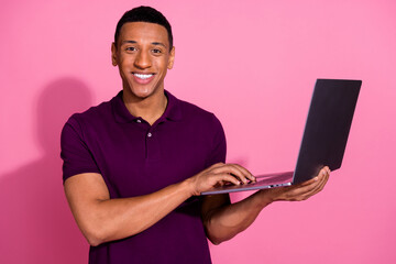 Photo portrait of nice young male hold netbook dressed stylish violet garment isolated on pink...