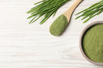 Wheat grass powder and fresh sprouts on white wooden table, flat lay. Space for text