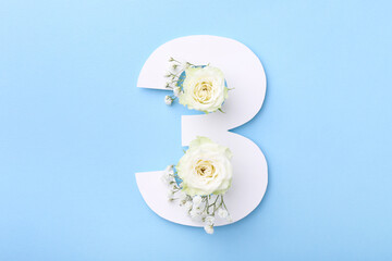 Paper number 3 and beautiful flowers on light blue background, top view