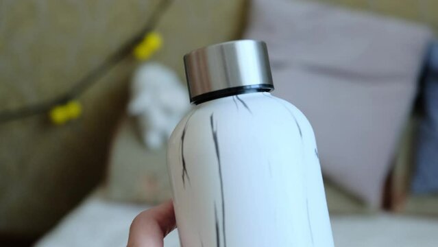 A woman's hand takes a bottle of water. Eco-friendly and zero waste concept.