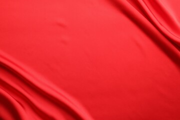 Crumpled red silk fabric as background, top view. Space for text