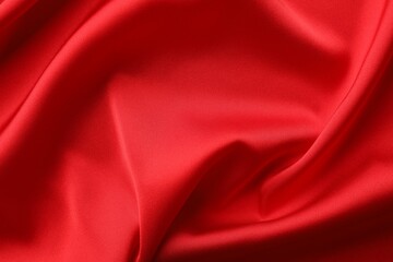 Crumpled red silk fabric as background, top view