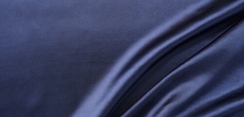 Crumpled dark blue silk fabric as background, top view. Space for text