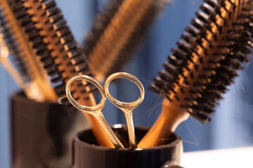 Close-up of hair scissors with thin and thick hair brushes. Hair scissors in selective focus....