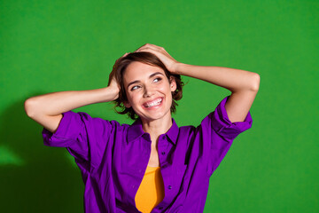 Portrait of young girl brown haired touching head emotional day relaxed look novelty wear violet shirt isolated on green color background