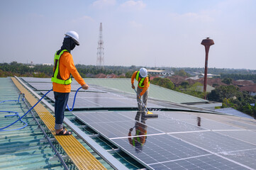 A team of engineers takes care of cleaning the solar panels outside the building. Installing solar...