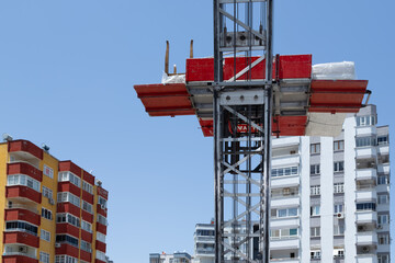 Transporting household goods by elevator to high-rise buildings by mobile vehicle. Carrying furniture up and down lift. Cargo, moving, changing house, moving goods, lift carrying idea. © CONQUEROR