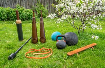 fitness equipment on green lawn in springtime scenery, backyard gym concept