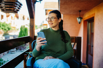 One young caucasian woman is using her smartphone to talk with friends or send messages while...