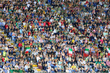 Intentionally blurred background of many people in the packed stands of the stadium during the...