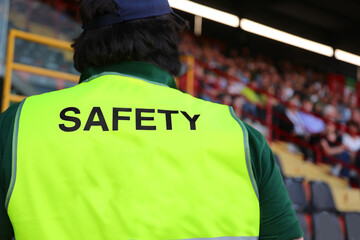 steward with the phosphorescent jacket and the large SAFETY writing who controls the fans in the...