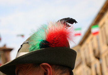 Head of the person wearing a hat with the black feather typical of the uniform of the Alpini mountain troops of the Italian Army and with a tricolor decoration