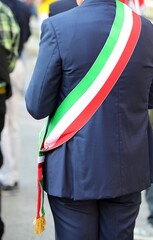 Elegant mayor of a city in Italy wearing the national tricolor green white and red sash