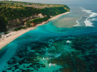 Drone view of Pandawa beach with turquoise ocean and waves in Bali