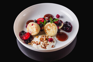 cottage cheese pancakes with berries and jam on a white plate