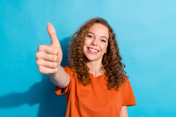 Portrait photo of youngster cheerful girl with beautiful curly red hair wearing orange t shirt...