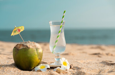Glass of Tender Coconut water with fresh coconut on the beach, healthy cool drink image