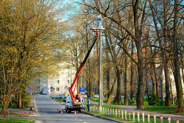 Aerial platform truck, painter at height painting and renew streetlight poles, urban maintenance...