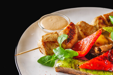 barbecue chicken and vegetables on a white plate
