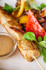 barbecue chicken and vegetables on a white plate