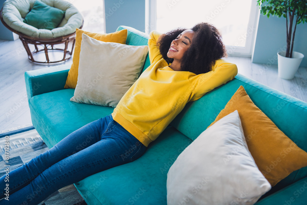 Wall mural Photo of attractive lovely pretty girl sitting on sofa arms behind head enjoying vacation in comfy room