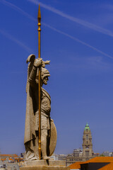 Sculpture of a man with spear and church tower in the background