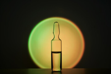 Ampoule for injection against the background of a bright yellow circle.