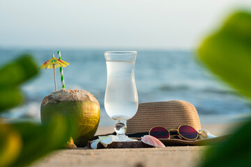 Fresh Coconut juice on the beach with hat and sunglass, Summer drink on a tropical beach