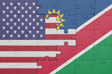 puzzle with the colourful national flag of namibia and flag of united states of america .