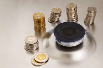 gas stove and coins on a gray background