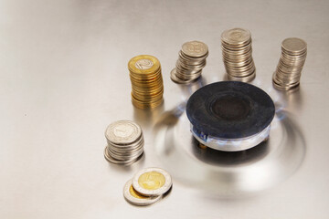 gas stove and coins on a gray background